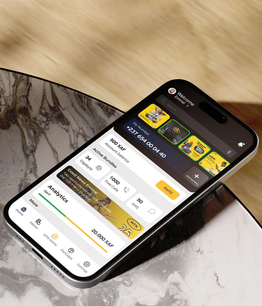 A smartphone on a marble table displaying the dark-mode home screen of the MTN Cameroon mobile app, showing the user's balance, data bonuses, and analytics.